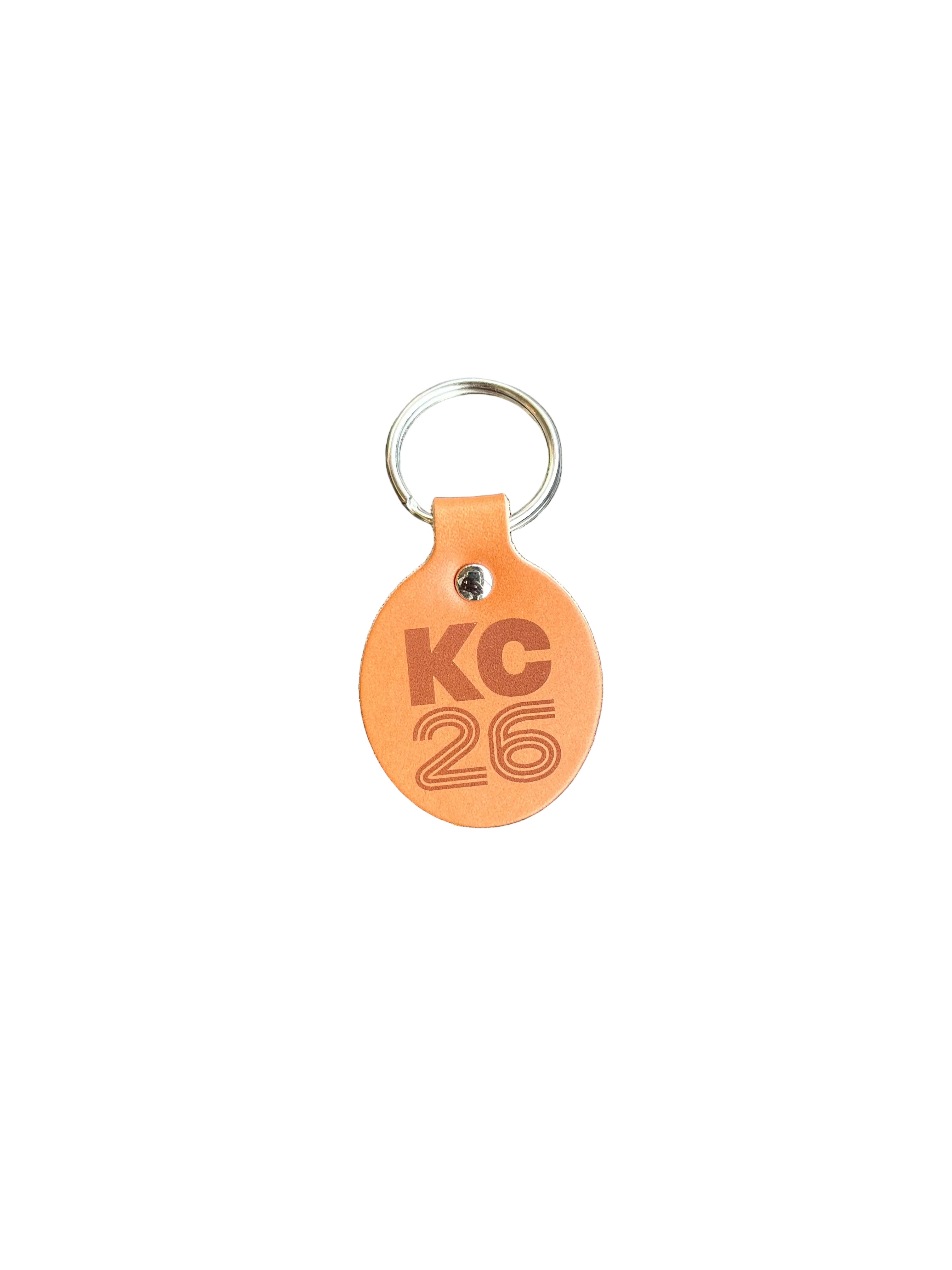 Leather keychain with 'KC 26' branding on a leather surface